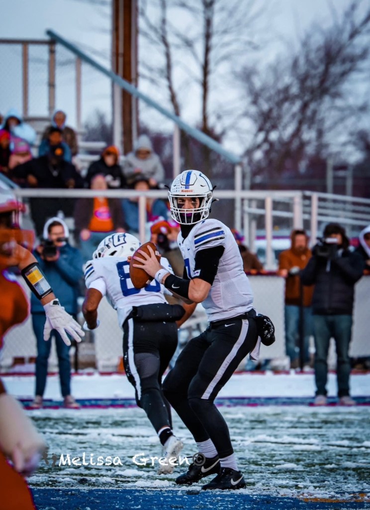 College football quarterback in a passing stance during a winter game